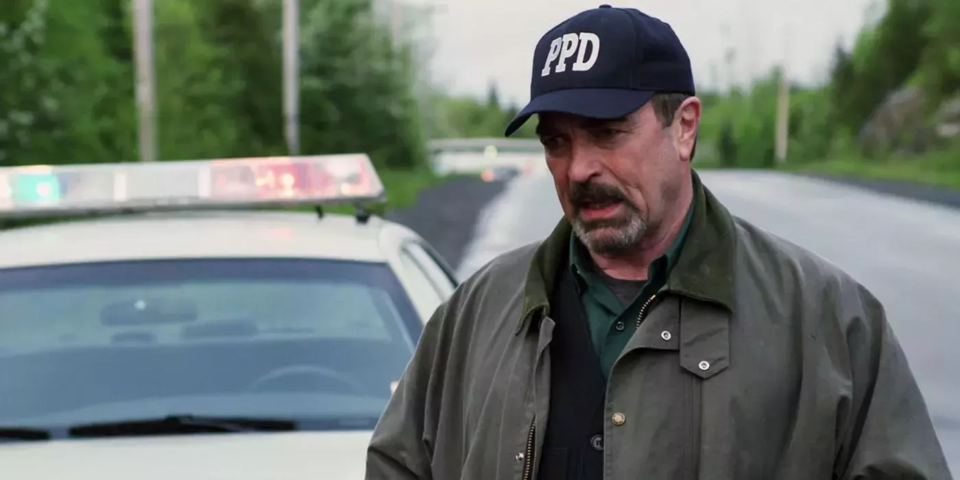 Jesse Stone (Tom Selleck) next to a cop car in Benefit of the Doubt