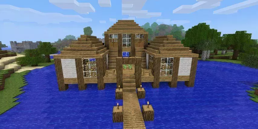 Minecraft house made of wood by the water and trees