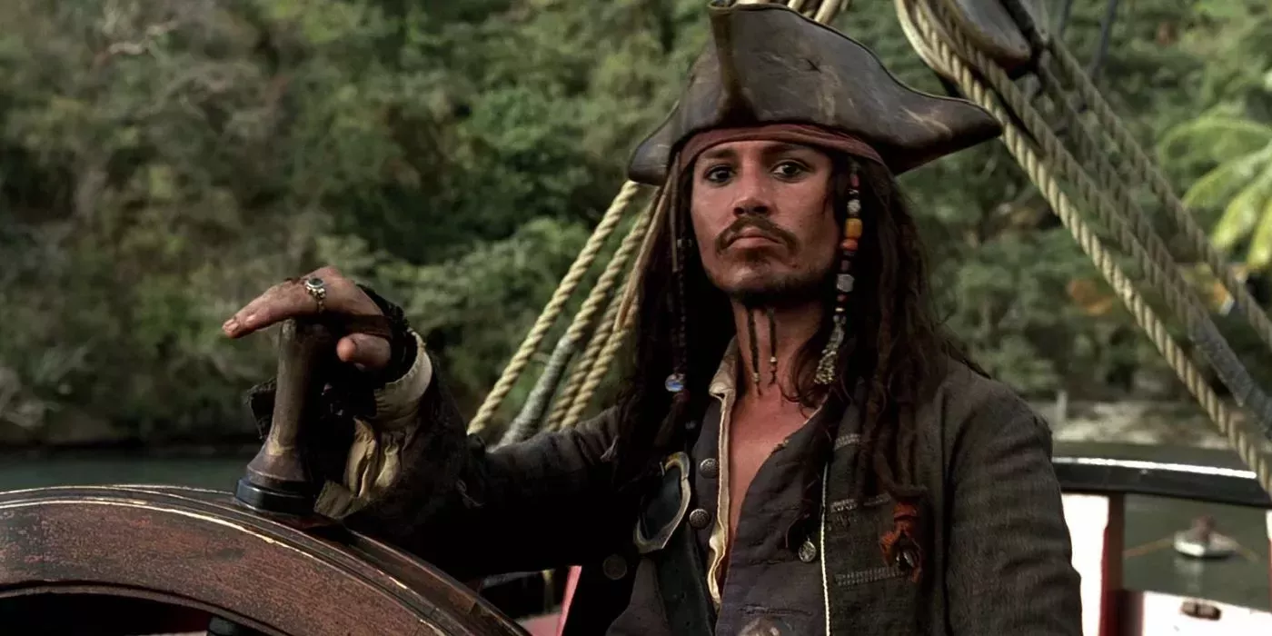 Jack Sparrow (Johnny Depp) has his hand on a ship's wheel in Pirates of the Caribbean: Curse of the Black Pearl.