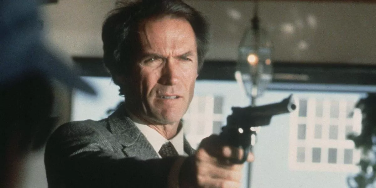 Clint Eastwood como Dirty Harry sosteniendo un arma apuntada hacia el lado derecho de la pantalla.