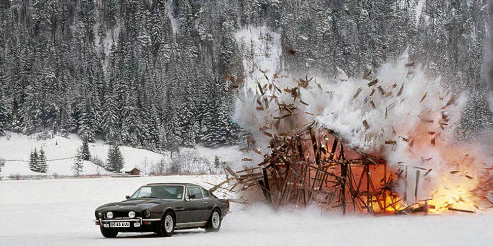 Bond drives away on ice from an exploding hut