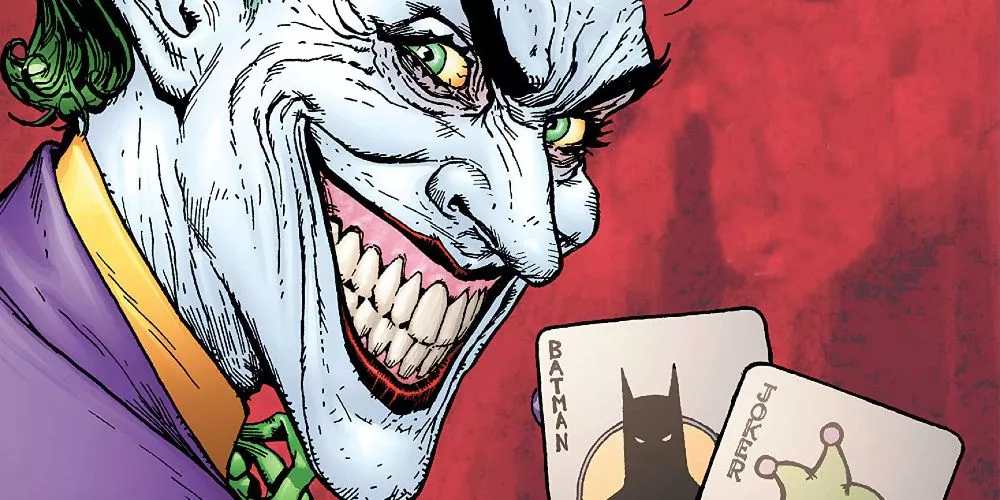 El Joker sonríe y sostiene dos cartas en DC Comics