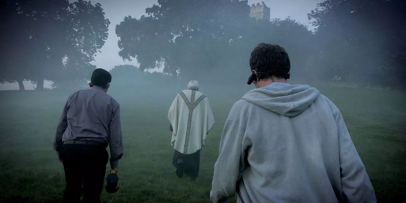 the borderlands - 2013 - found footage british folk horror - walking through a field with a priest