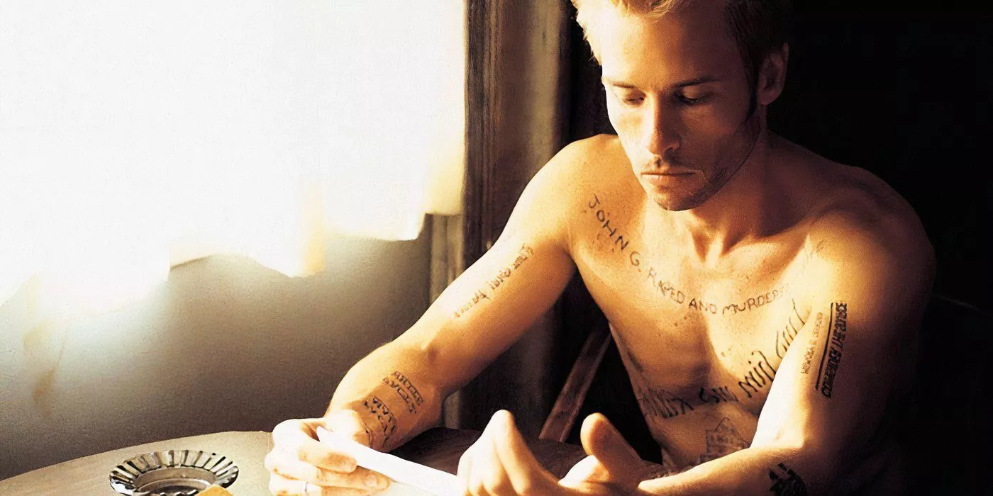 Leonard is looking at his notes and tattoos in Memento