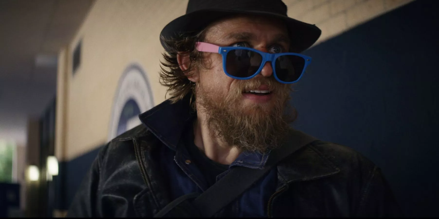 Charlie Hunnam con barba desaliñada, sombrero y gafas de sol de plástico en Last Looks