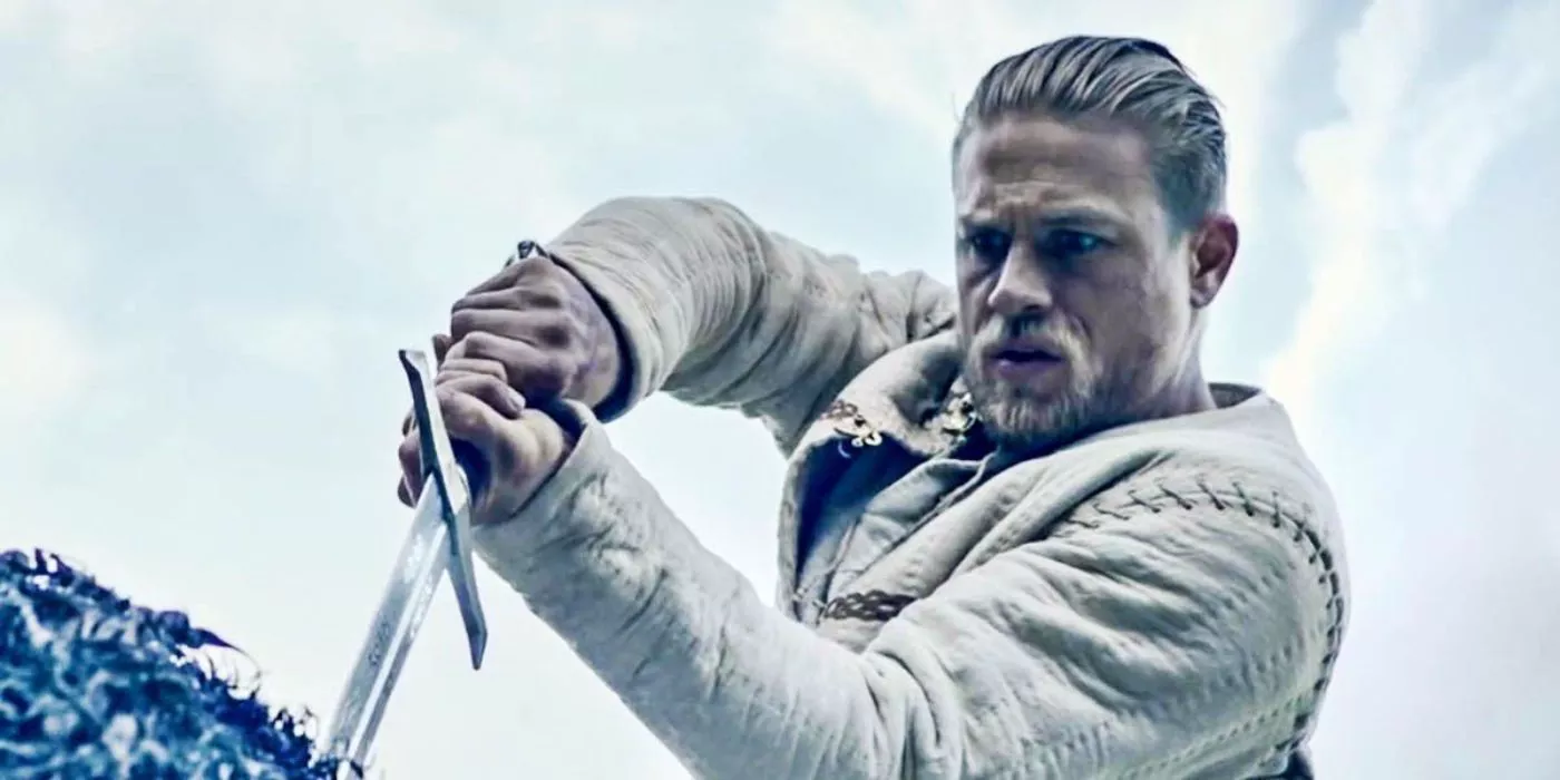 Charlie Hunnam como Rey Arturo saca la espada de la piedra en Rey Arturo: La Leyenda de la Espada.