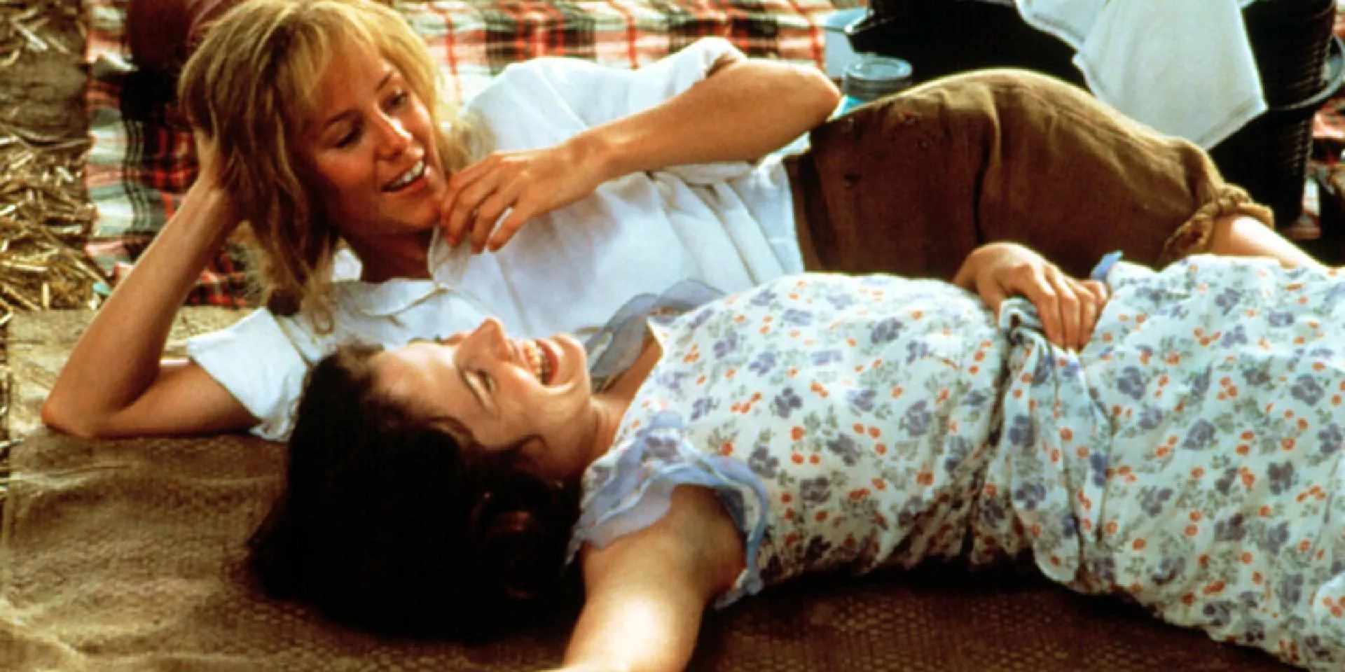 Idgie (Mary Stuart Masterson) and Ruth (Mary-Louise Parker) laying on a blanket and laughing in Fried Green Tomatoes.