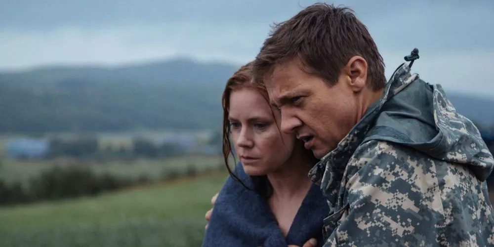 Louise Banks standing on a hill while being comforted by Ian Donnelly in Arrival.