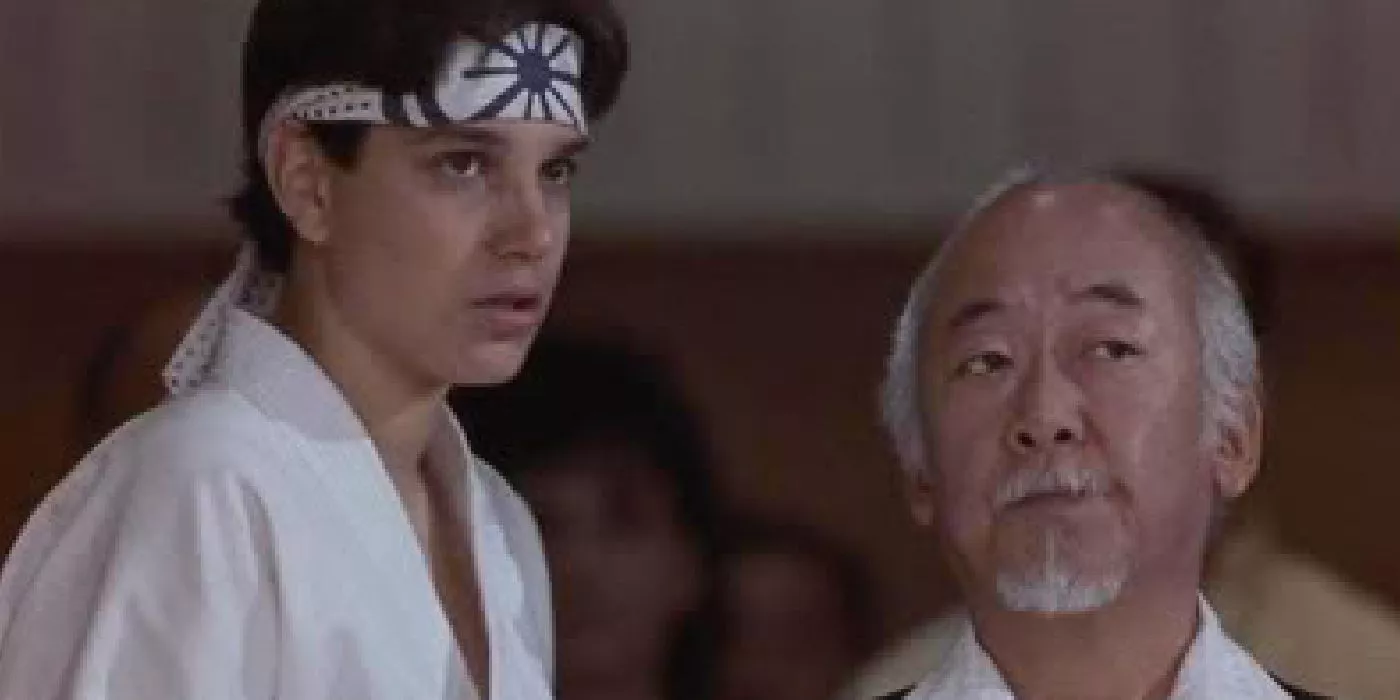 Daniel and Mr. Miyagi in Karate Kid Part 3 looking intently at someone.