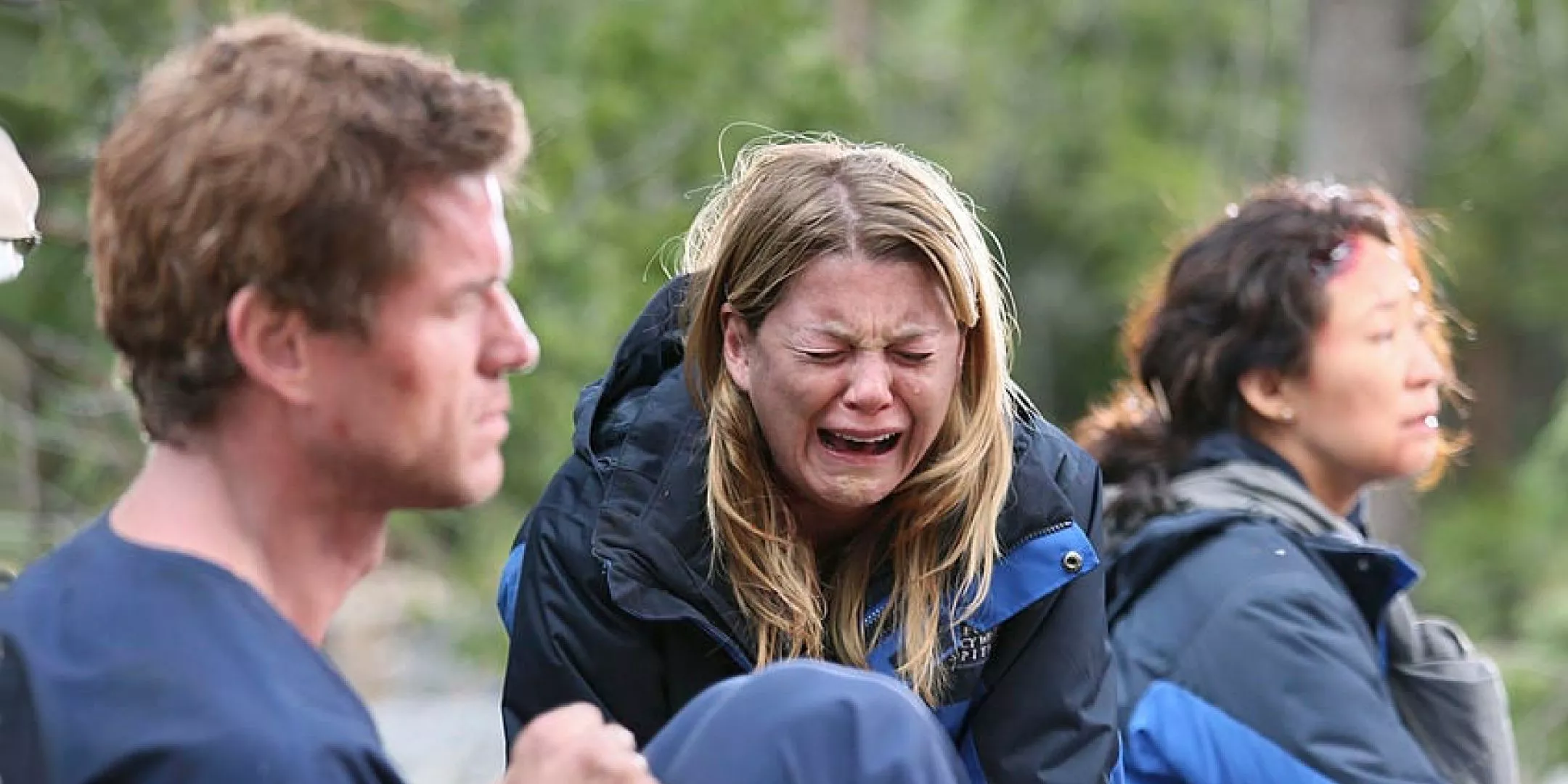 Meredith sobs between Mark and Cristina after the plane crash in Grey's Anatomy