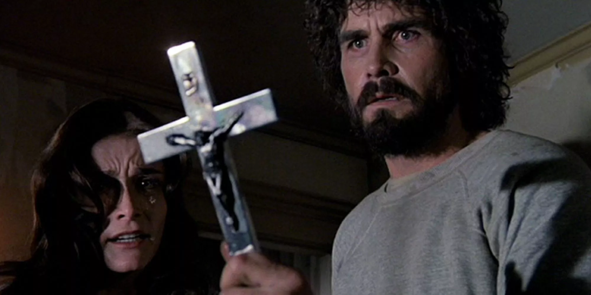 George holds a crucifix in The Amityville Horror