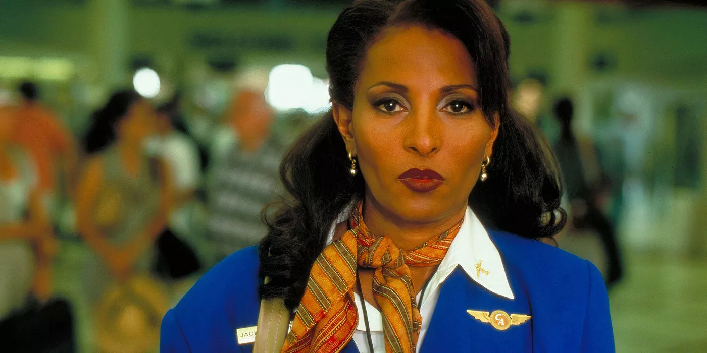 Pam Grier como Jackie Brown a punto de agarrar un paquete de drogas en el aeropuerto y contrabandeándolo en Jackie Brown.