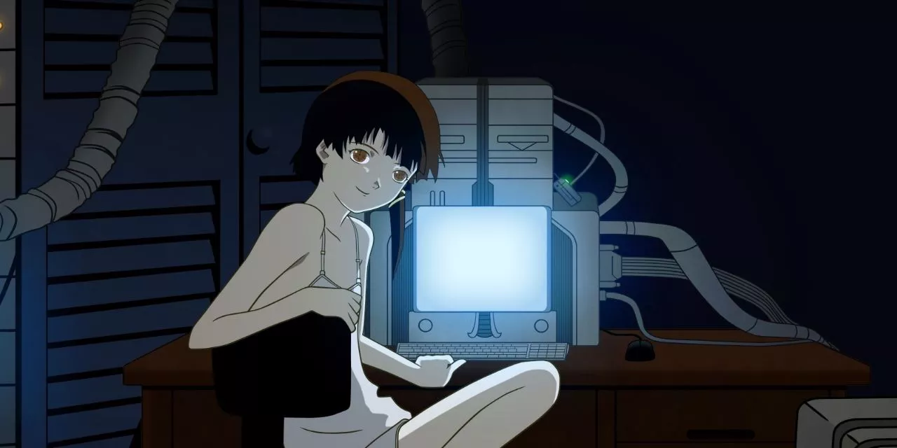 Lain in Serial Experiments Lain smiling at the viewer while sitting at a computer.