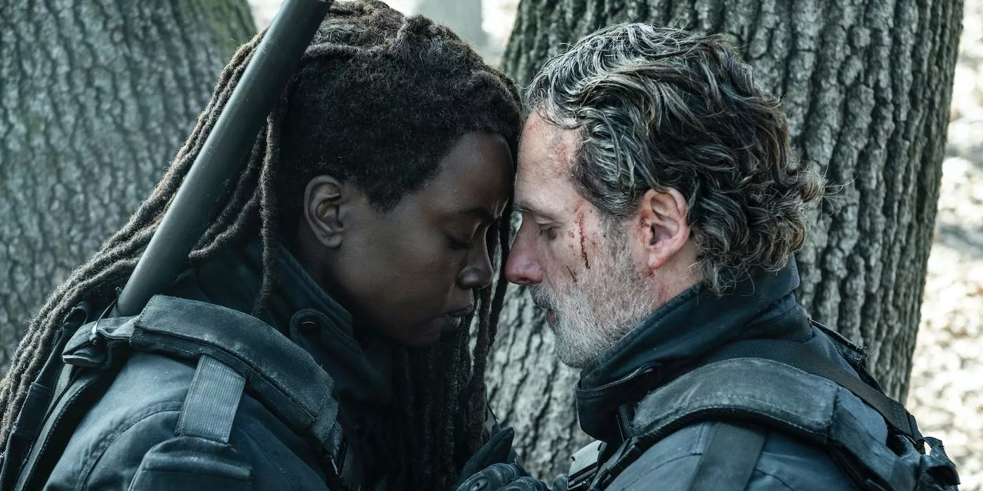 Michonne y Rick Grimes se abrazan detrás de un árbol en The Walking Dead: The Ones Who Live