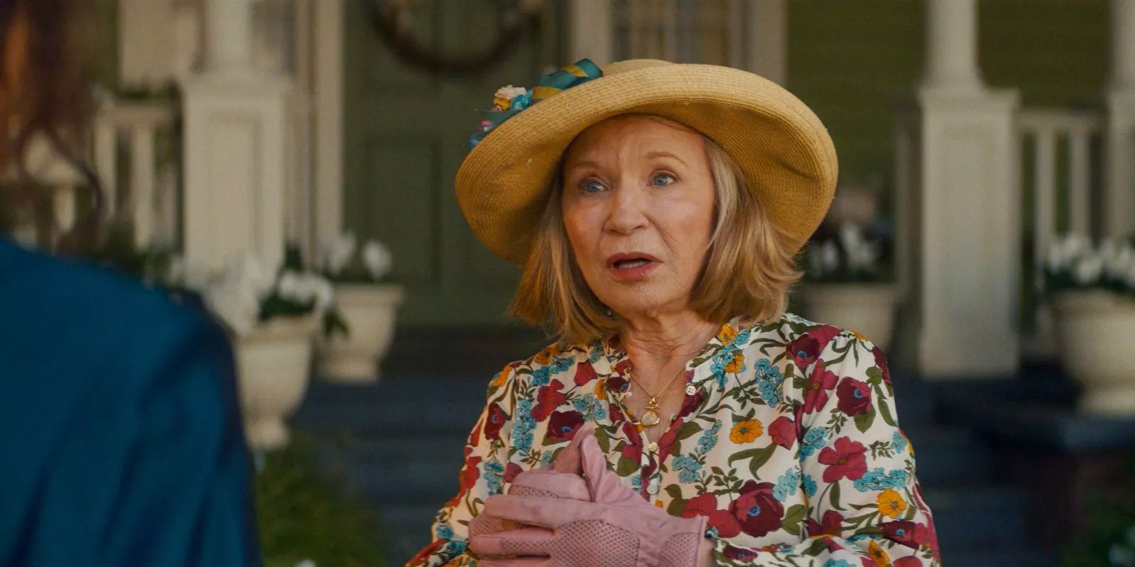 Debra Jo Rupp as Sharon Davis standing in front of her house in Agatha All Along.