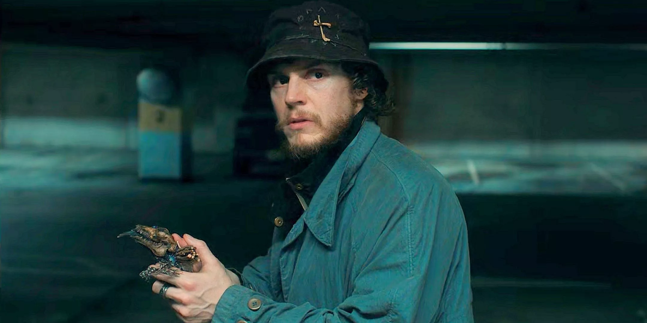 Evan Peters as Ralph Bohner covered holding an anti-witch totem and looking rough in a parking garage from Agatha All Along.