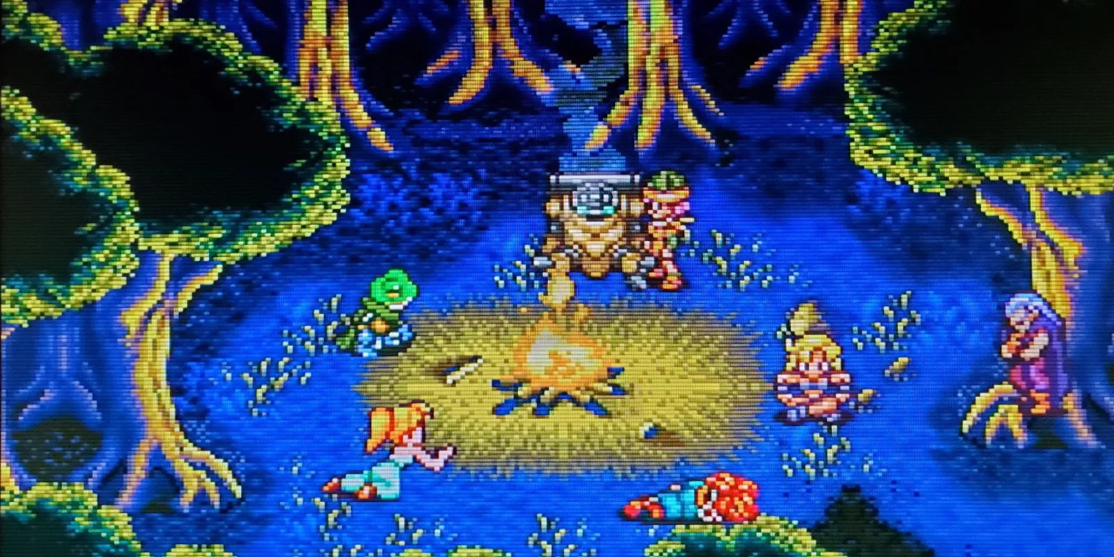 Marle, Frog, Robo, Lucca, Ayla, Magus, y Crono sentados alrededor de una fogata en Chrono Trigger