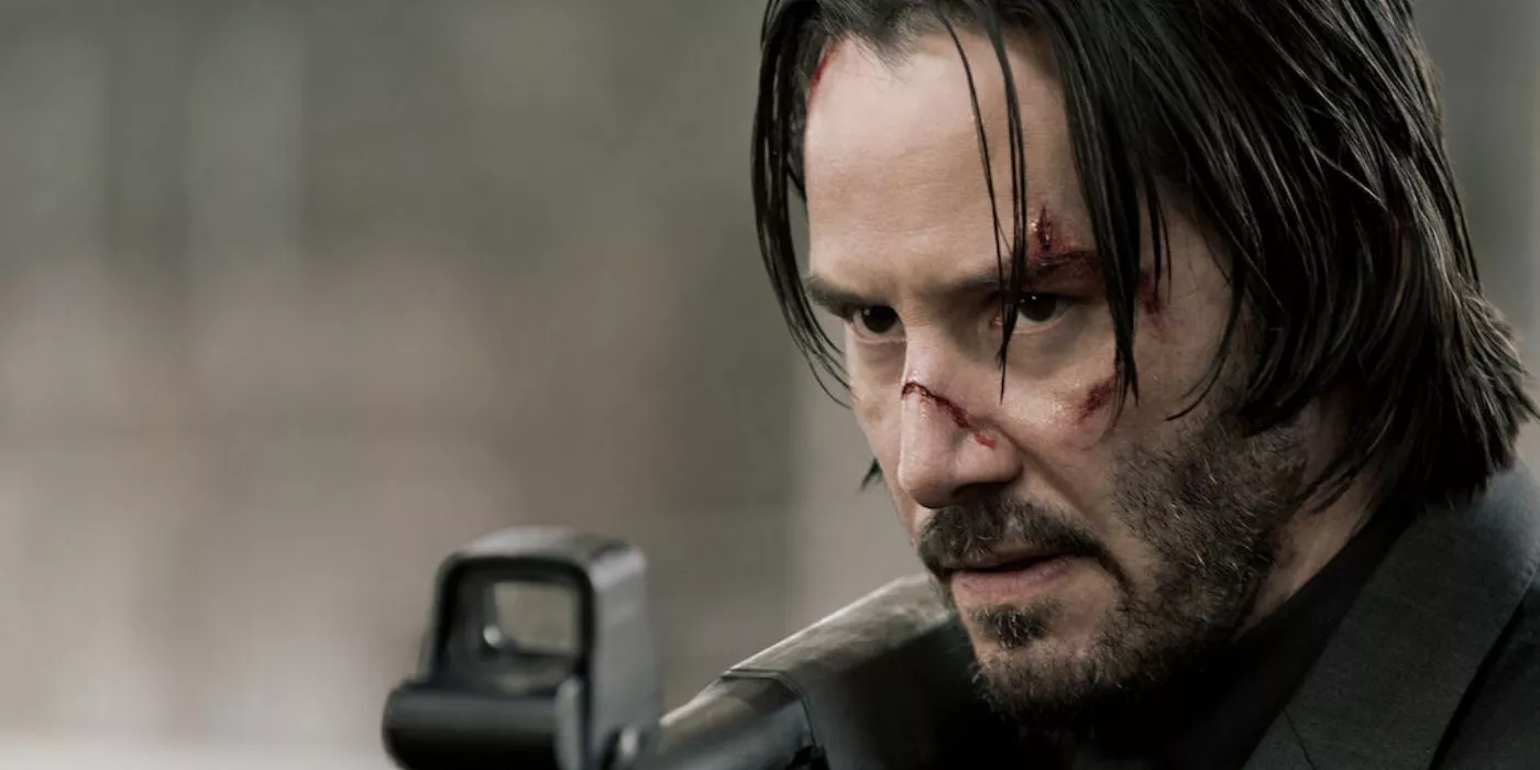 John Wick looks ultra serious down the crosshairs of his weapon.