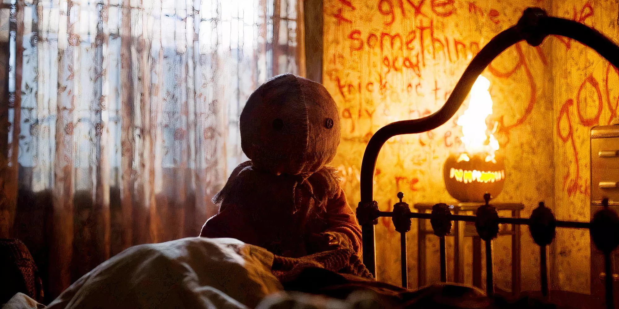 Sam is sitting in a bedroom with writing on the walls in Trick 'r Treat