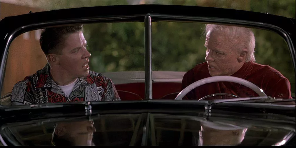 El Biff Tannen de 2015 le da el almanaque deportivo a Biff Tannen de 1955 en Regreso al Futuro Parte II.