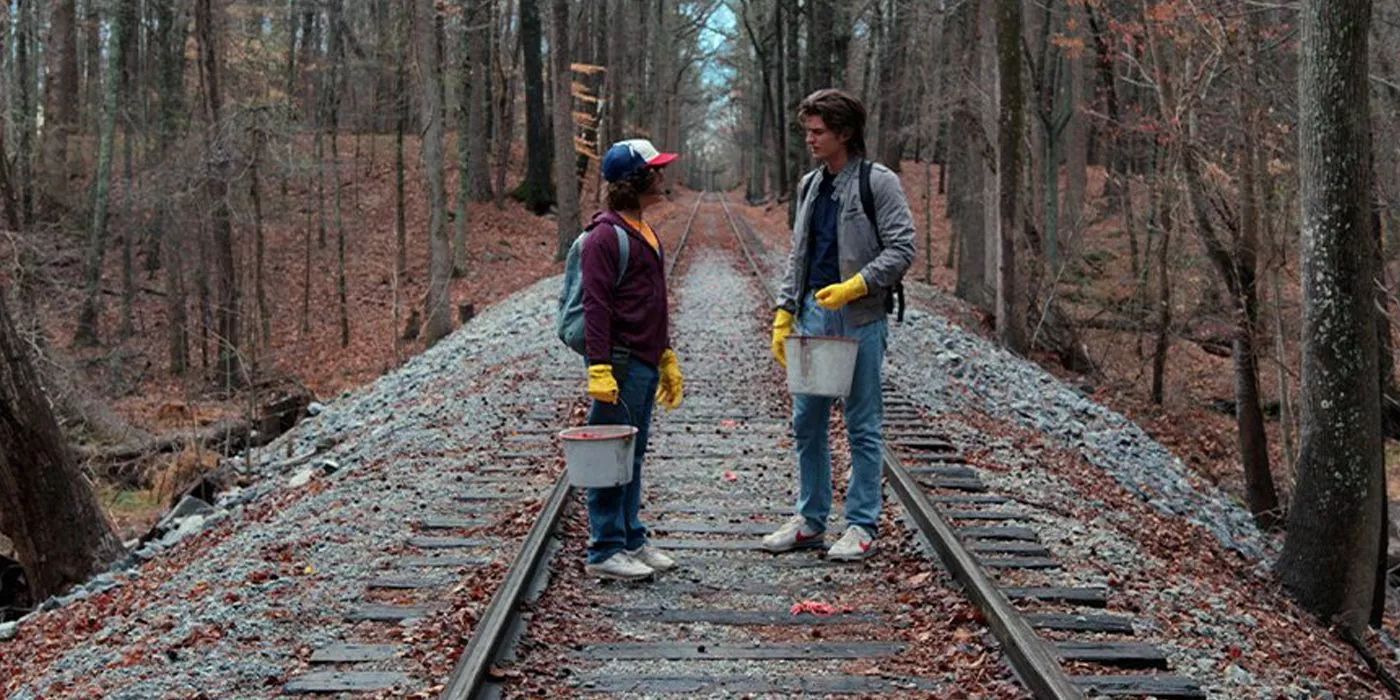 Dustin and Steve walk down the train tracks in a homage to Stand by Me in Stranger Things