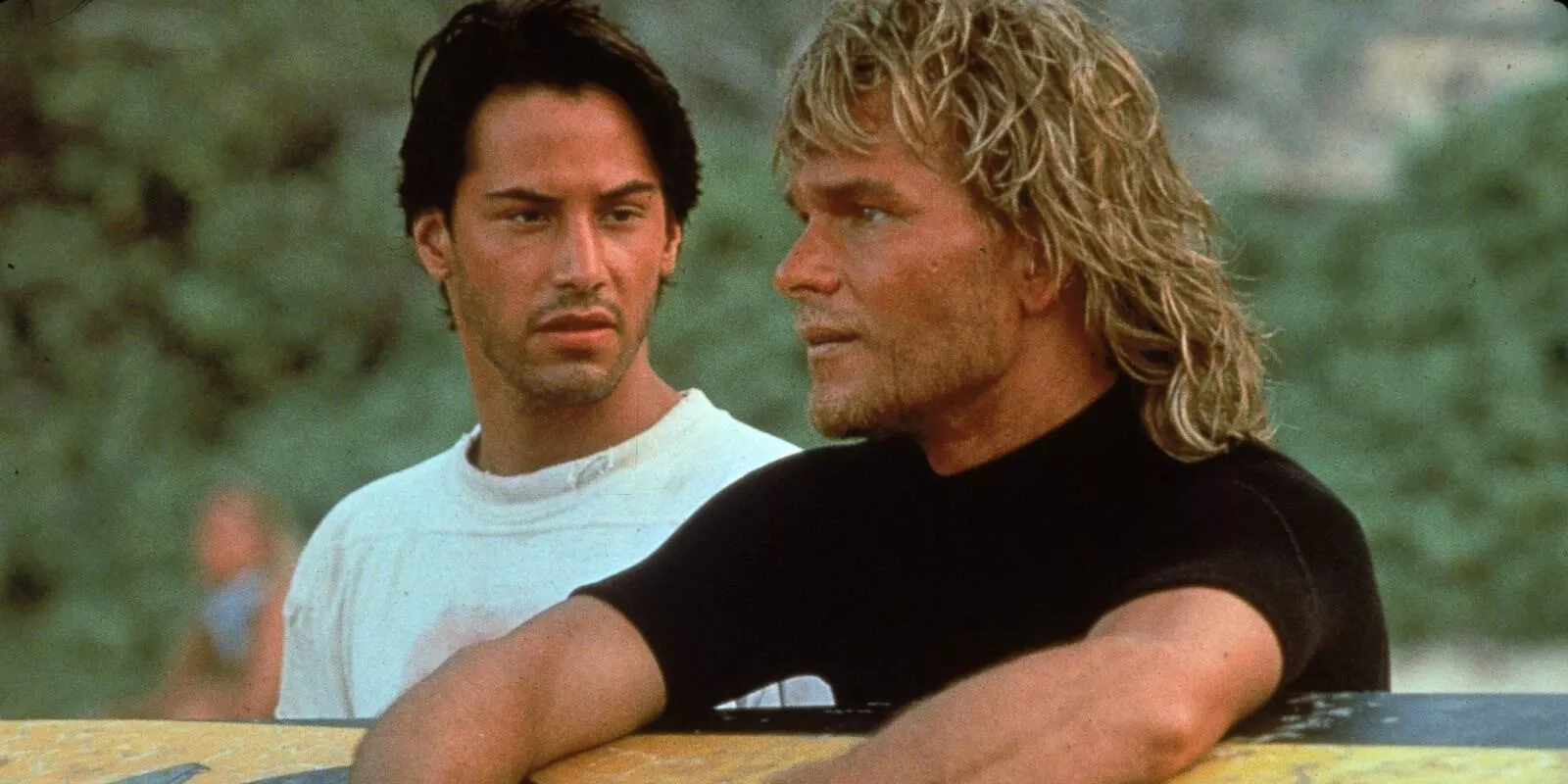 Keanu Reeves' Johhny Utah looking at Patrick Swayze's Bodhi in Point Break.