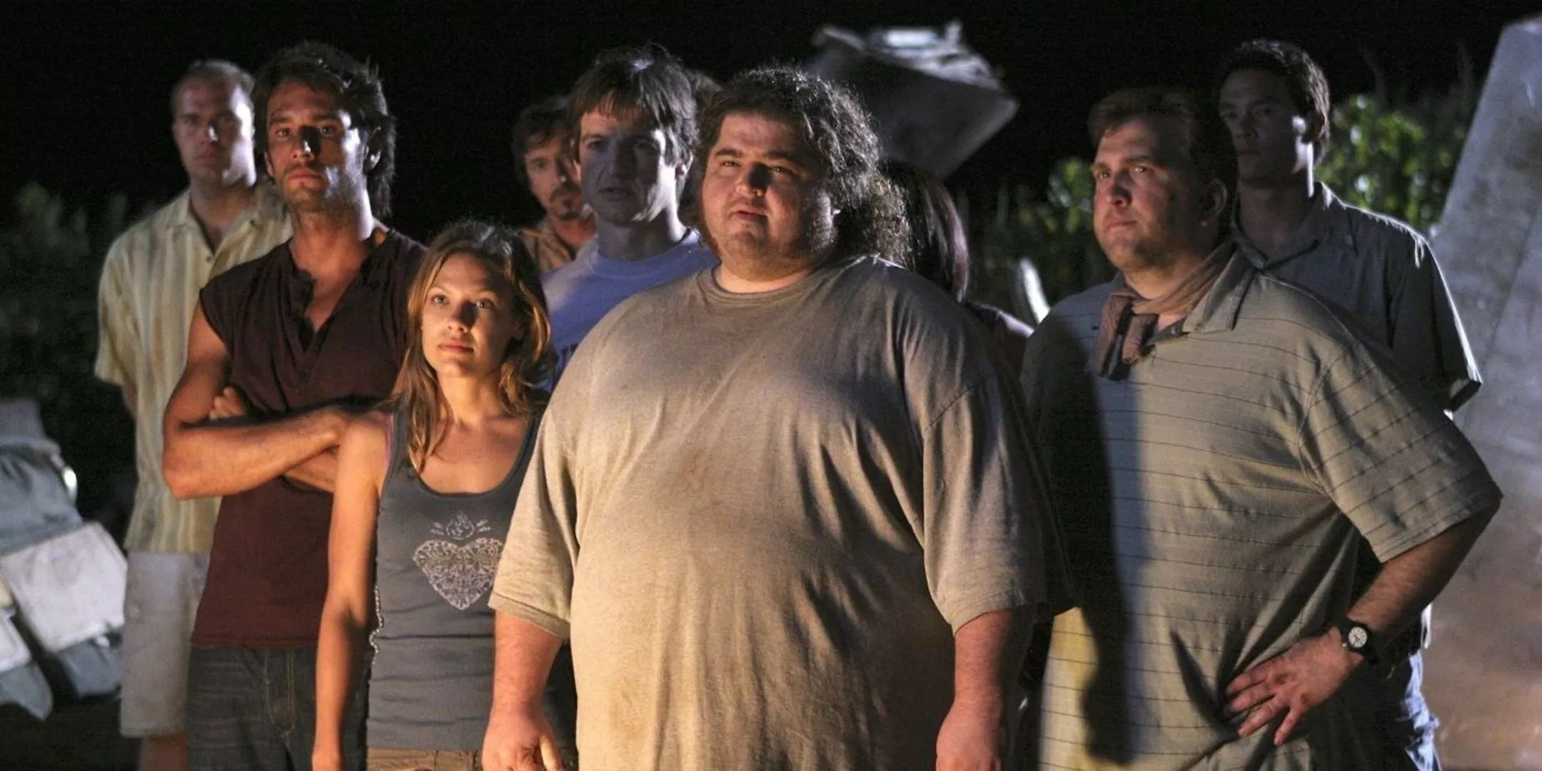 Paulo, Nikki, Hurley and Doctor Leslie Arzt standing in a group on the beach amid plane wreckage from the Lost series