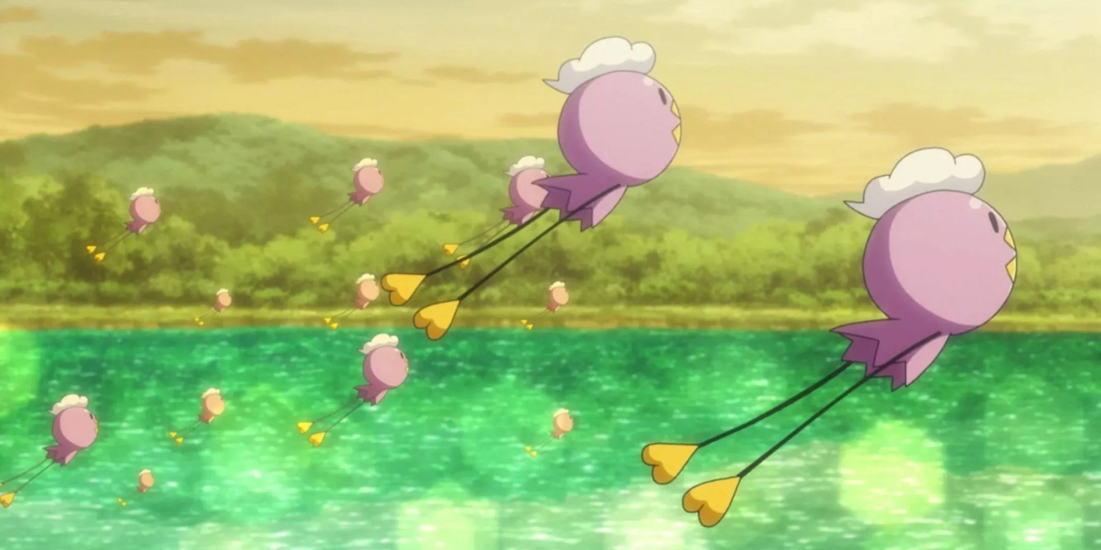 Un grupo de Drifloon flota sobre un lago brillante con una montaña boscosas de fondo en Pokémon