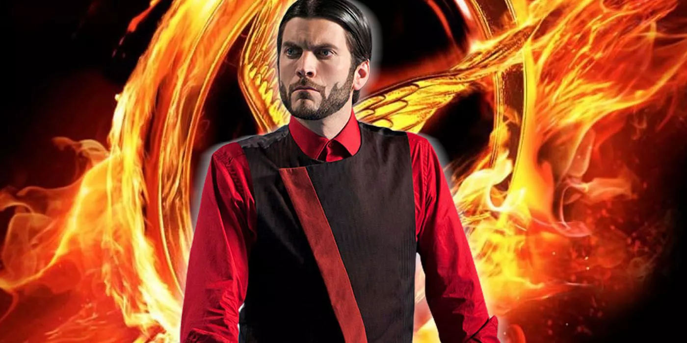 Wes Bentley as Seneca Crane in front of burning mockingjay pin from The Hunger Games.