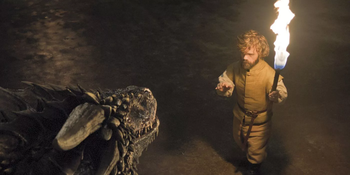 Tyrion intenta calmar a uno de los dragones de Dany mientras sostiene una antorcha en Game of Thrones