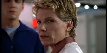 Professor Maggie Walsh stands in front of Riley in Buffy the Vampire Slayer