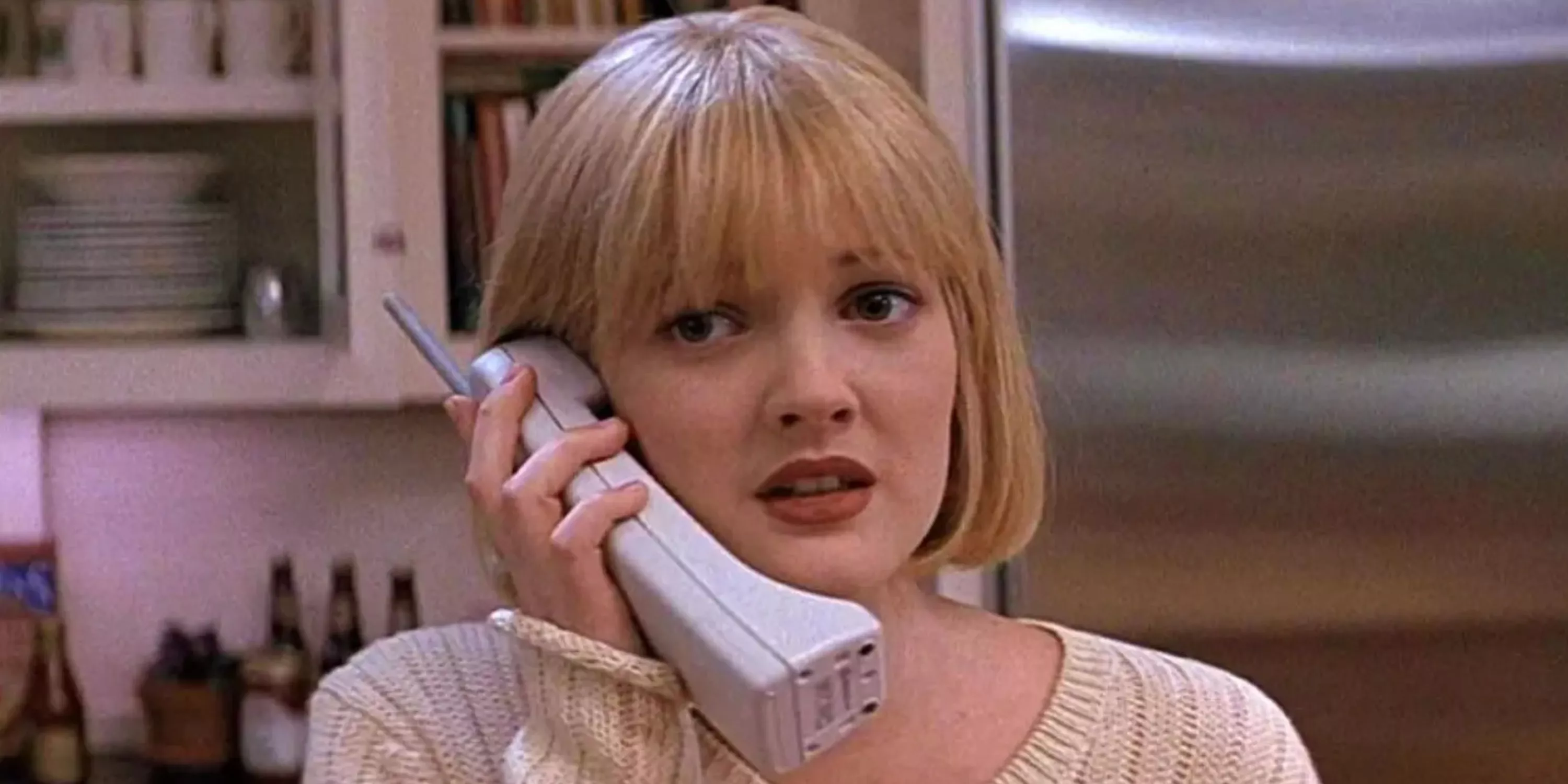 Drew Barrymore usando el teléfono durante los eventos de la película original Scream (1996)