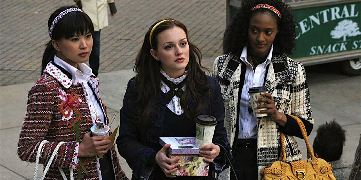 Blair holds a coffee and a box while standing next to her friends in Gossip Girl.