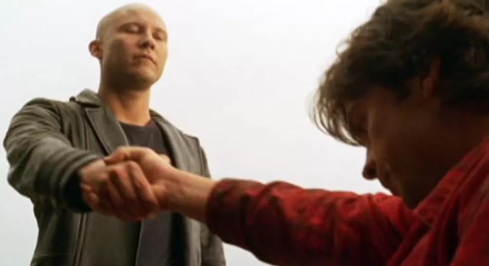 Clark gives his hand to Lex who is possessed by Zod in Smallville.