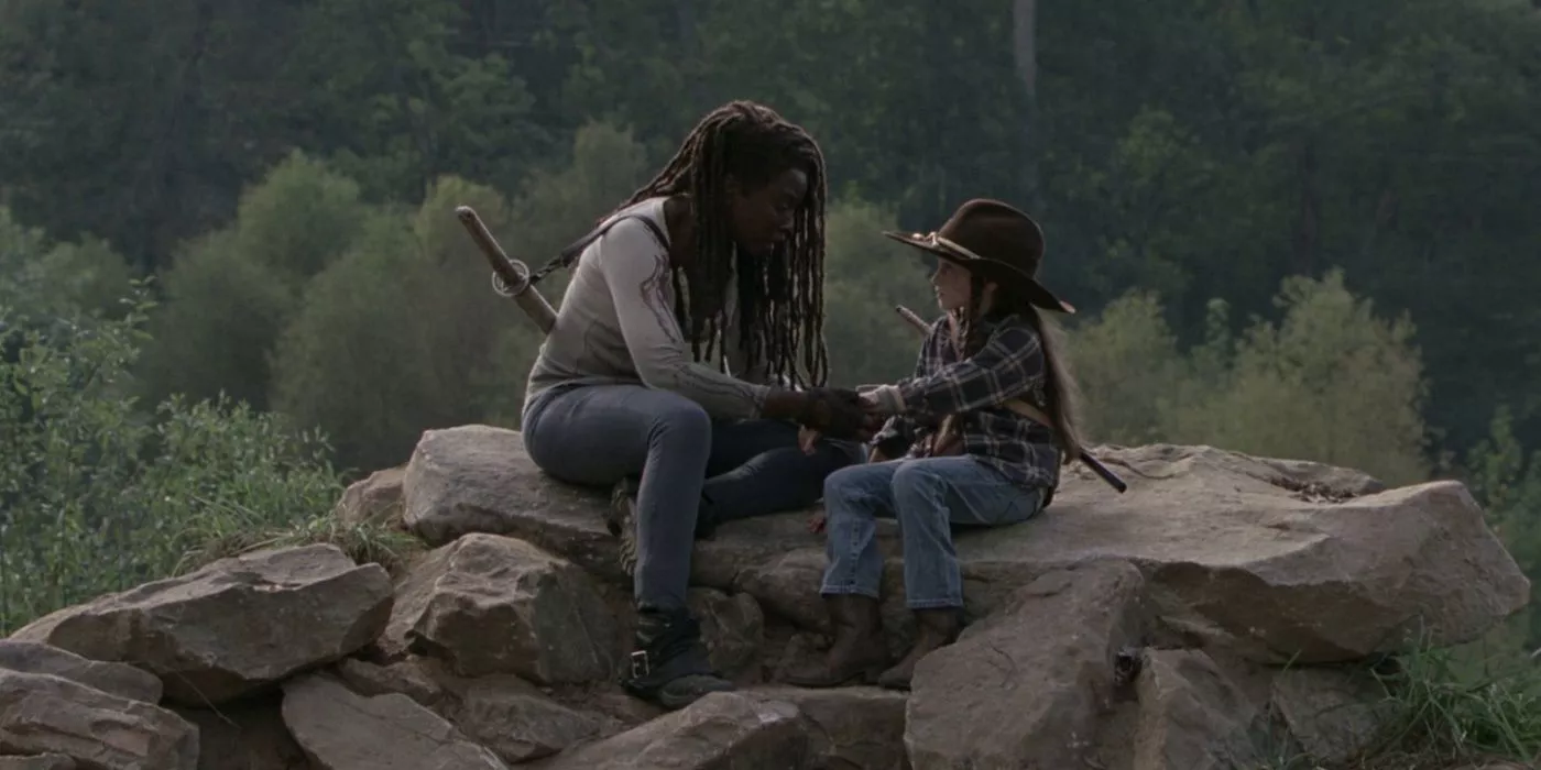 Michonne and Judith sitting together in The Walking Dead.